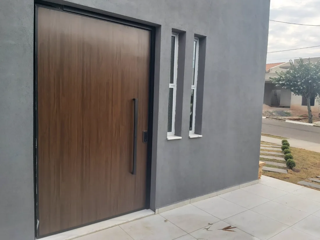 Entrada com porta pivotante de madeira em casa entregue pela S2B