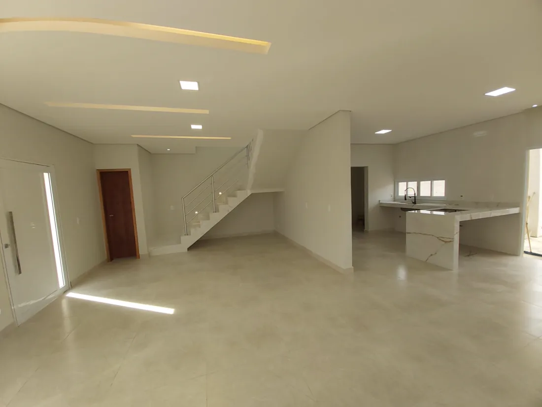 Sala ampla com escada e pé-direito alto